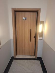 a wooden door in a room with a hallway at Enea Apartments 9 in Tirana