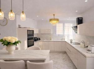 a kitchen with white cabinets and a table with chairs at Maison exceptionnelle - 6 pers - 3 chambres - Centre in Sablé-sur-Sarthe