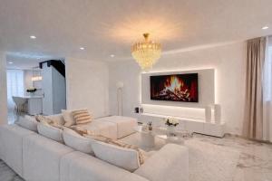 a living room with a white couch and a chandelier at Maison exceptionnelle - 6 pers - 3 chambres - Centre in Sablé-sur-Sarthe