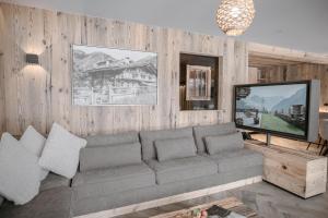 a living room with a couch and a television at BRUGGER ApartHotel in Mayrhofen