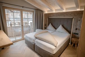 a bedroom with a bed and a large window at BRUGGER ApartHotel in Mayrhofen