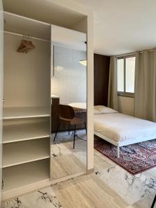 a bedroom with a mirror and a bed and a table at Cozy Studio, Pool & Beaches 2 min away in Roquebrune-Cap-Martin