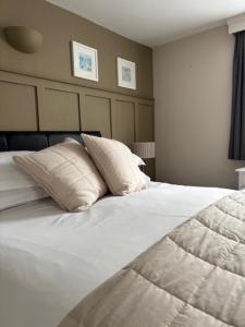 a large white bed with two pillows on it at Canterbury Guest House in Sidmouth