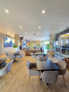 a restaurant with tables and chairs and a lobby at Alambique Hotel Express in Arandas