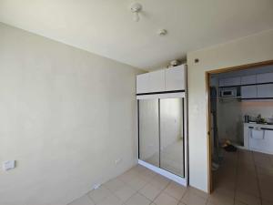 an empty room with a glass door to a kitchen at Steve's Condo in Davao City +2 photos