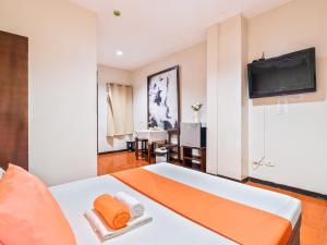 a room with a bed and a tv on a wall at California Signature Suites in Sudtungan