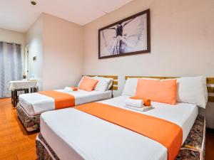 two beds in a room with orange and white at California Signature Suites in Sudtungan +57 photos