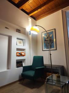 a living room with a green chair and a lamp at La Contrada - Suite Apartment in Sarnico +18 photos