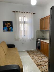 a living room with a couch and a kitchen at Unejs Apartment in Berat