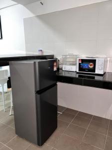 a kitchen with a black refrigerator and a microwave at GR studio APARTMENT 1 - kompleks MUTIARA gua MUSANG in Gua Musang