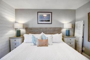 a bedroom with a large white bed with two lamps at Bay Tree A3 in Port Aransas