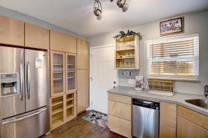 a kitchen with a stainless steel refrigerator and wooden cabinets at Bay Tree A3 in Port Aransas +36 photos