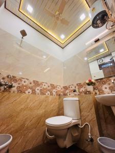 a bathroom with a toilet and a sink at Hogwood in Agra +15 photos