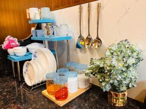 a counter with plates and bowls and utensils at Hogwood in Agra