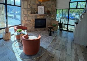 a living room with a stone fireplace and chairs at Best Western Johnson's Inn Downtown Gatlinburg in Gatlinburg +36 photos