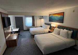 a hotel room with two beds and a desk at Best Western Johnson's Inn Downtown Gatlinburg in Gatlinburg
