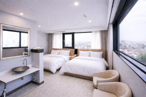 a hotel room with two beds and a window at Seoul Ahava Hotel in Seoul