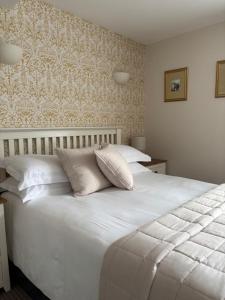 a white bed with white pillows in a bedroom at Canterbury Guest House in Sidmouth +17 photos