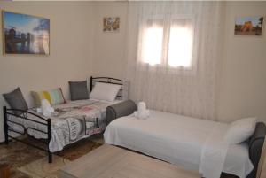 a bedroom with two beds and a window at Stone-built house Vrontados Chios 3' from beach in Vrontádos