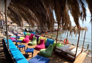 a row of colorful chairs on a beach at Stone-built house Vrontados Chios 3' from beach in Vrontádos