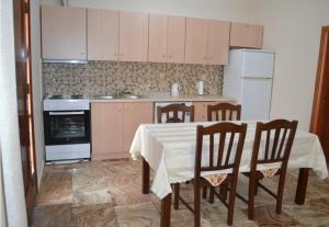 a kitchen with a table with chairs and a stove at Stone-built house Vrontados Chios 3' from beach in Vrontádos +27 photos