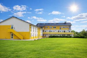 a large building with a green field in front of it at i-Motel Obertshausen nahe Frankfurt in Obertshausen