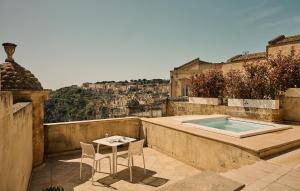 a patio with a table and chairs and a swimming pool at Palazzo Gattini - The Leading Hotels of the World in Matera
