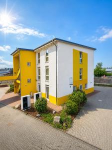 a yellow and white building on a street at i-Motel Obertshausen nahe Frankfurt in Obertshausen