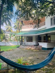 a hammock in front of a building at H Villa in Nilambūr