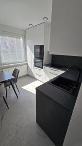 a kitchen with a black counter top and a table at Cozy apartment in Šiauliai