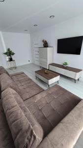 a living room with a large couch and a flat screen tv at Cozy apartment in Šiauliai