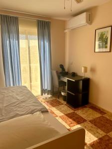 a bedroom with a bed and a desk and a window at Casa Marta in Beniarjó