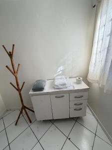 a small white table with a cup on top of it at Repouso Tranquilo in Assis
