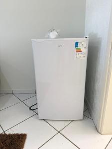 a white refrigerator sitting in a corner of a room at Repouso Tranquilo in Assis +8 photos
