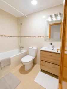 a bathroom with a toilet and a sink and a tub at La Riviera Residence in Rojales