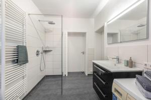 a bathroom with a glass shower and a sink at Ferienwohnung Dicke Linde, 55qm in Schmallenberg +13 photos
