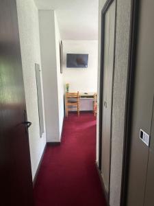 a hallway with a red carpet and a table at HUMAN HOTEL RESTAURANT Park in Villecroze