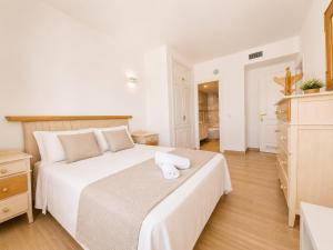 a bedroom with a large white bed with towels on it at G&G Isla Marina Puerto in Benalmádena +16 photos