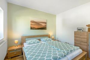 a bedroom with a bed and a painting on the wall at Ferienwohnung Dicke Linde, 55qm in Schmallenberg