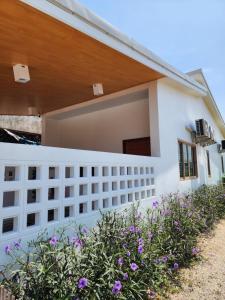 a white house with a fence and flowers at 19 House in Ban Khlong Pleo