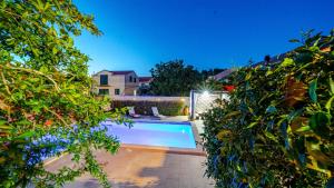 a swimming pool in a yard with trees at Villa Anna by Villas Guide in Vela Luka