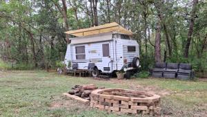 an rv parked in a field with a pile of bricks at Caravan Rustic Sunflower in Mount Crosby