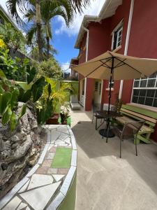a patio with a table and an umbrella at Glynver Apartments in Christ Church