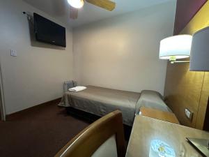 a small hotel room with a bed and a table at Hotel coventry in Santiago del Estero