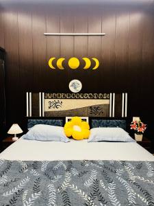 a bedroom with a large bed with yellow stuffed animals on it at Oakèra in Agra