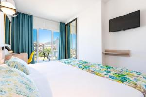 a bedroom with a white bed and a large window at San Fermín by Dorobe in Benalmádena +50 photos