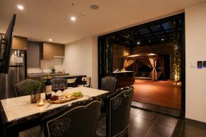 a dining room with a table and chairs and a kitchen at Seoul Ahava Hotel in Seoul