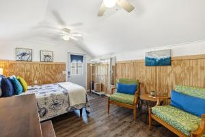 a bedroom with a bed and two chairs at Fisher Flats Downstairs in Cedar Key