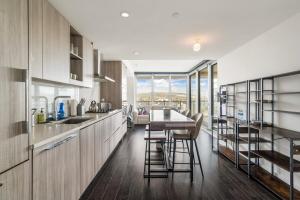 a kitchen with wooden cabinets and a table and chairs at Bright & Cozy 1BR Steps to Brentwood mall in Burnaby