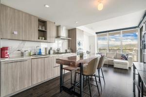 a kitchen with a table and chairs and a couch at Bright & Cozy 1BR Steps to Brentwood mall in Burnaby +9 photos